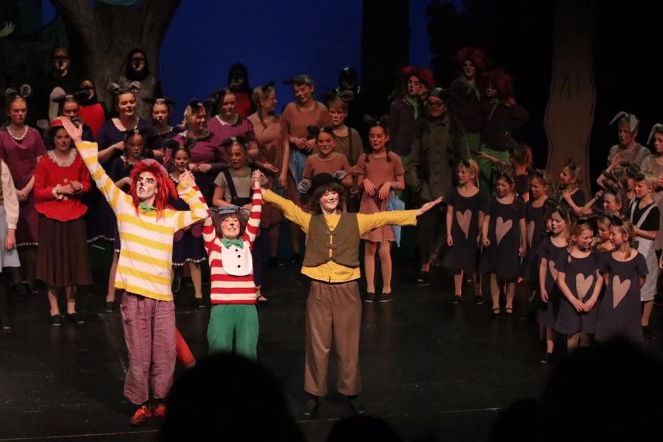 Hele ensemblet på scenen med armene i været